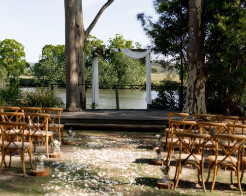 Riverside wedding ceremony setting with draped arbour at The Rocks Yandina